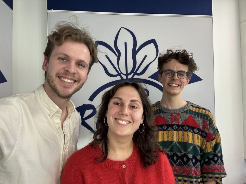 Drei Personen lächeln vor dem Logo des Radio Radieschen.