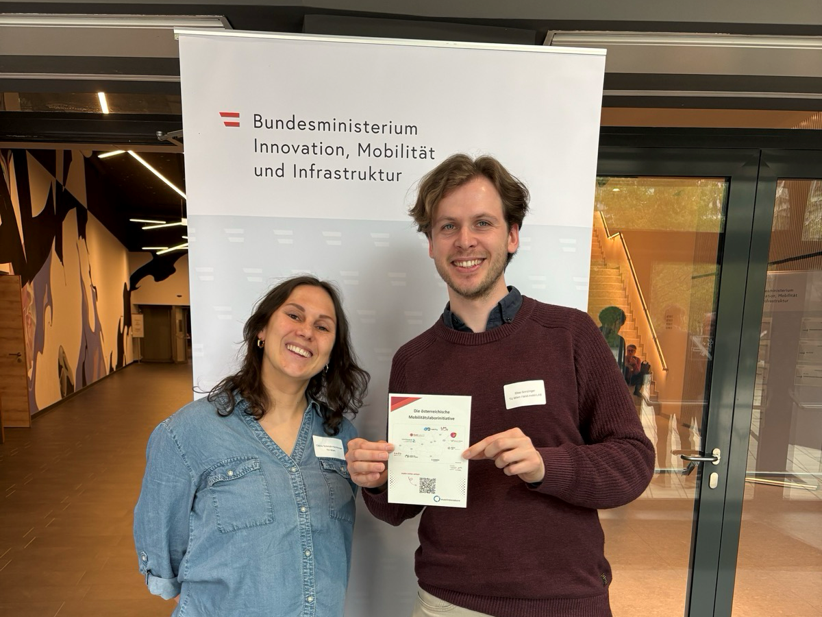 Ein Mann und eine Frau posieren vor einem Banner.